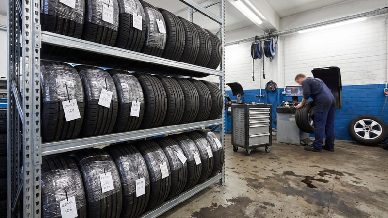 Reifenregal mit beschrifteten Kundenreifen-Sätzen in der Werkstatt